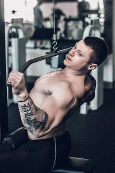 close up. male bodybuilder uses the simulator to strengthen the muscles of the chest