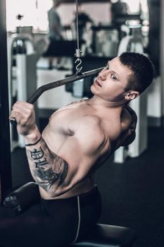 close up. male bodybuilder uses the simulator to strengthen the muscles of the chest