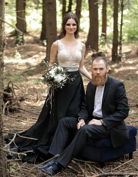 portrait of a bride and groom in a pine forest.