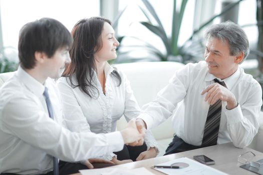 closeup.the financial partners shaking hands over Desk in office