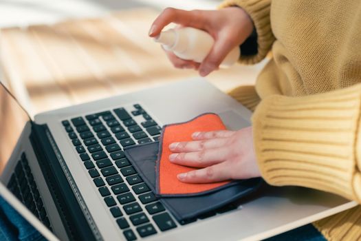 close up. young woman treating her laptop from viral bacteria. photo with a copy of the space