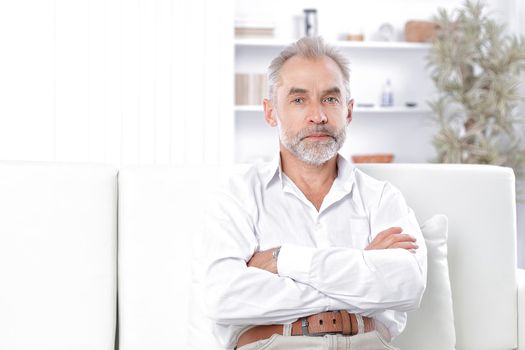 smiling businessman sitting on sofa in office.