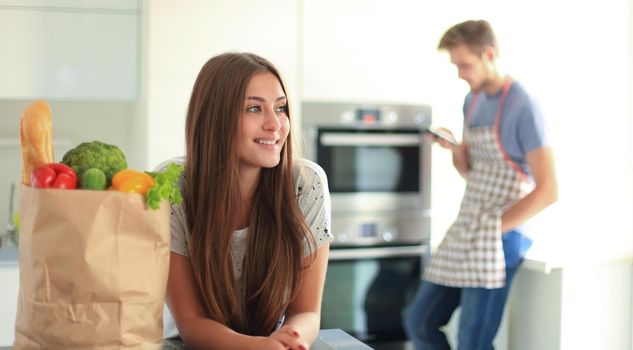 Young couple in the kitchen , woman with a bag of groceries shopping