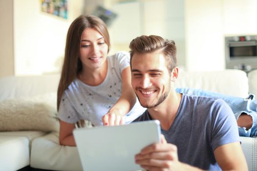 Happy couple in love surfing on tablet at home