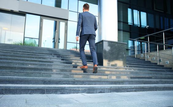 Business executive with briefcase going up the stairs.