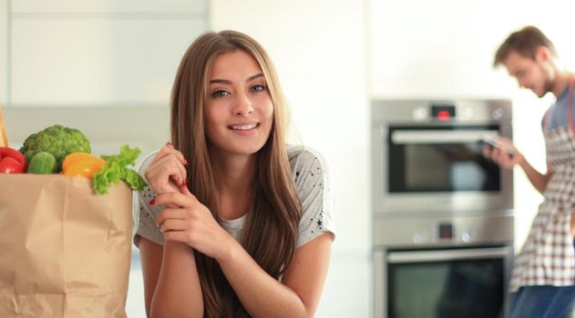 Young couple in the kitchen , woman with a bag of groceries shopping