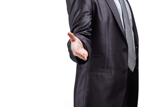 successful businessman reaches out for a handshake.isolated on grey background.