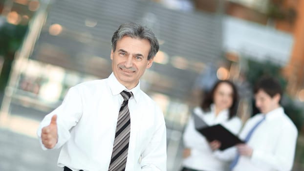 smiling businessman holding out his hand for greeting . the concept of cooperation .