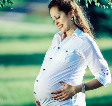 beautiful pregnant woman on a walk in the Park on a summer day