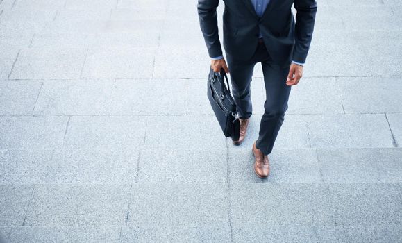 Business executive with briefcase going up the stairs.