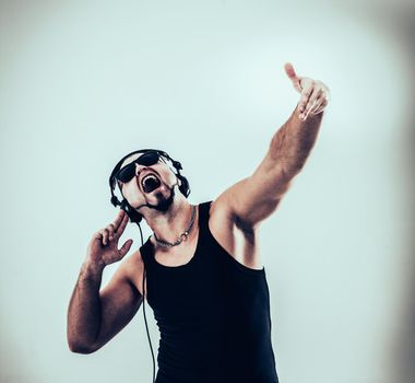DJ - rapper in headphones takes the rap and break dancing dance on a light background.the photo has a empty space for your text