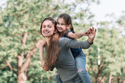 mom plays with her daughter in the spring garden. the concept of happiness