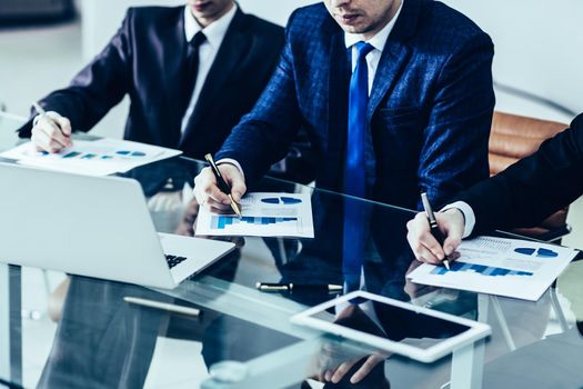 closeup of business team discussing a new financial plan of the company in the workplace in the office