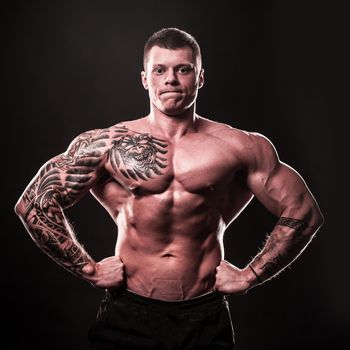 muscular male bodybuilder showing his muscles.isolated on black background
