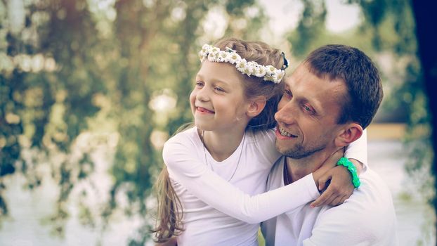 fatherhood - happy father and little daughter hugging each other in the Park on a Sunny day