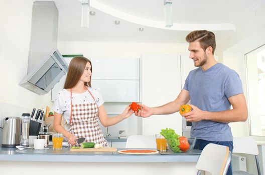 Young couple making pizza in kitchen together