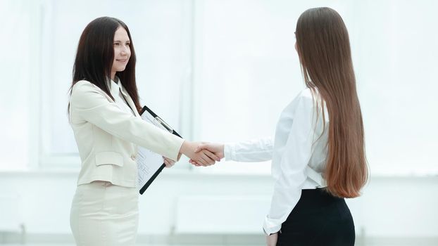 successful business woman shaking hands with employee.