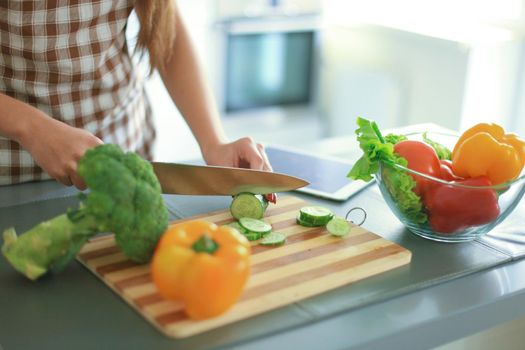 Beautiful young couple is looking at each other and smiling while cooking in kitchen at home.