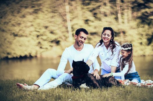 happy father of a daughter and a pregnant mom in the picnic.