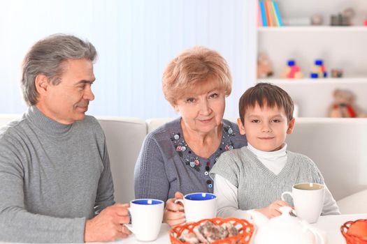 Boy Drinking Hot Chocolate and Happy Grandparents.