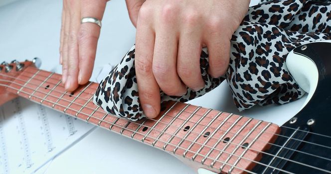 closeup.rock guitarist,wiping the neck of the guitar .photo with copy space