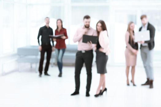 background image of a business team talking in the office hall.