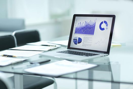 laptop, clipboard and financial data on the businessman's Desk.