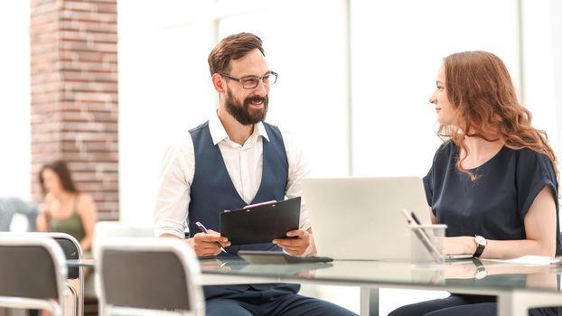 two employees discussing new ideas while sitting at the Desk.photo with copy space