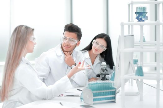 close up.a team of scientists discussing something at the Desk . science and health