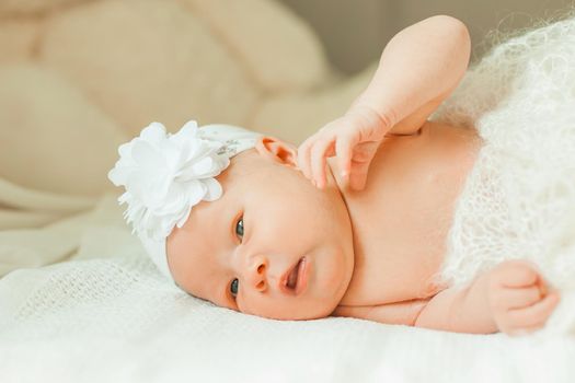 newborn baby girl in a beautiful bonnet lying on a blanket. photo with copy space