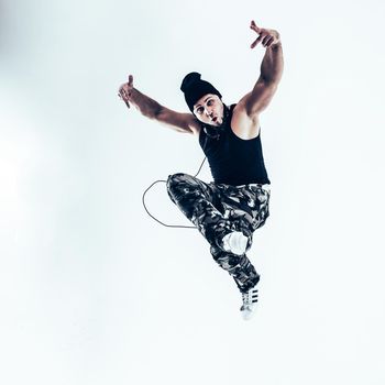 rapper with headphones takes breakdancing. photo on a white background and has an empty space for your text
