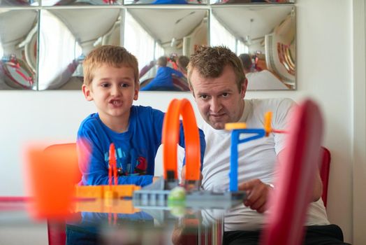 Father and children playing kids stunt racing toy car game