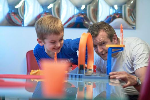 Father and children playing kids stunt racing toy car game