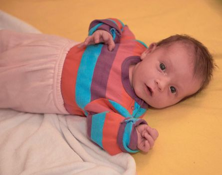 One month newborn baby in bed. Close up portrait of sleeping cute little girl