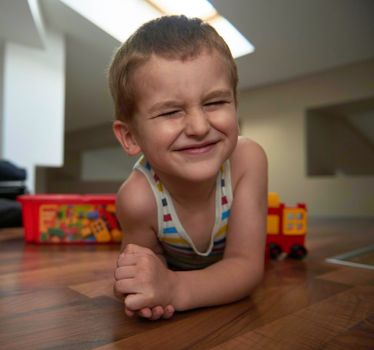 Little boy child playing with creative plastic toys indoor, building different cars and building  objects