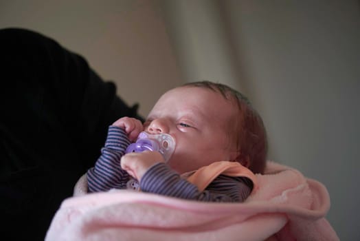 happy grandmother holding newborn baby at home