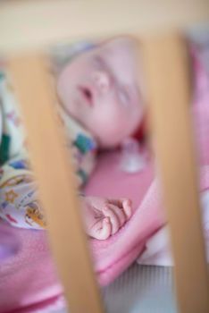 newborn baby girl sleeping in bed at home