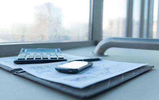 calculator, smartphone and financial documents on the businessman's Desk. business concept