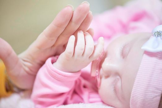 mother is playing with newborn baby at home