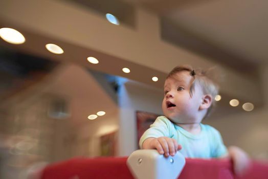 cute  little baby playing with toys in mobile bed making first steps and learnig to stand  and walk