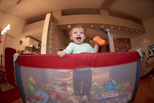 cute  little baby playing with toys in mobile bed making first steps and learnig to stand  and walk