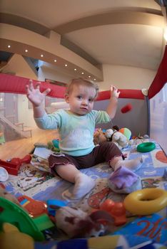 cute  little baby playing with toys in mobile bed making first steps and learnig to stand  and walk