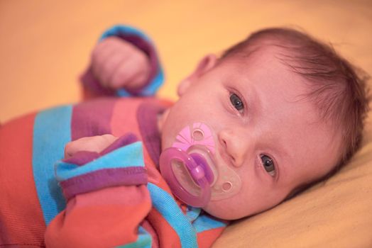 One month newborn baby in bed. Close up portrait of sleeping cute little girl