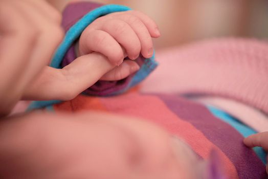 mother is playing with newborn baby at home