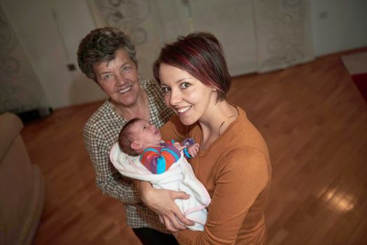 generations family portrait with grandparents parents  and  newborn baby
