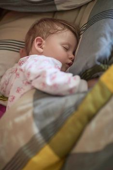 newborn baby girl sleeping in bed at home