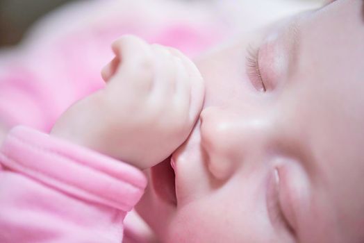 newborn baby girl sleeping in bed at home