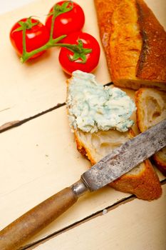 fresh blue cheese spread ove french baguette with cherry tomatoes on side