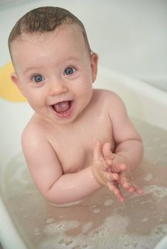 Mother is bathing happy little  baby girl taking a bath