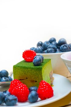 green tea matcha mousse cake with raspberries and blueberries on top